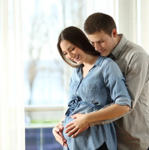 couple holding each other happy about baby in stomach. 