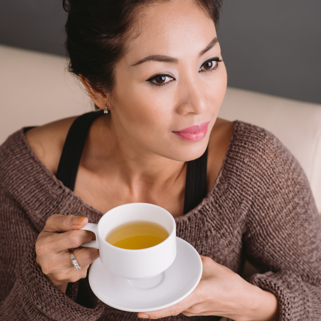 asian woman drinking green tea on couch