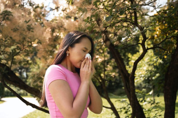 Side view woman blowing her nose