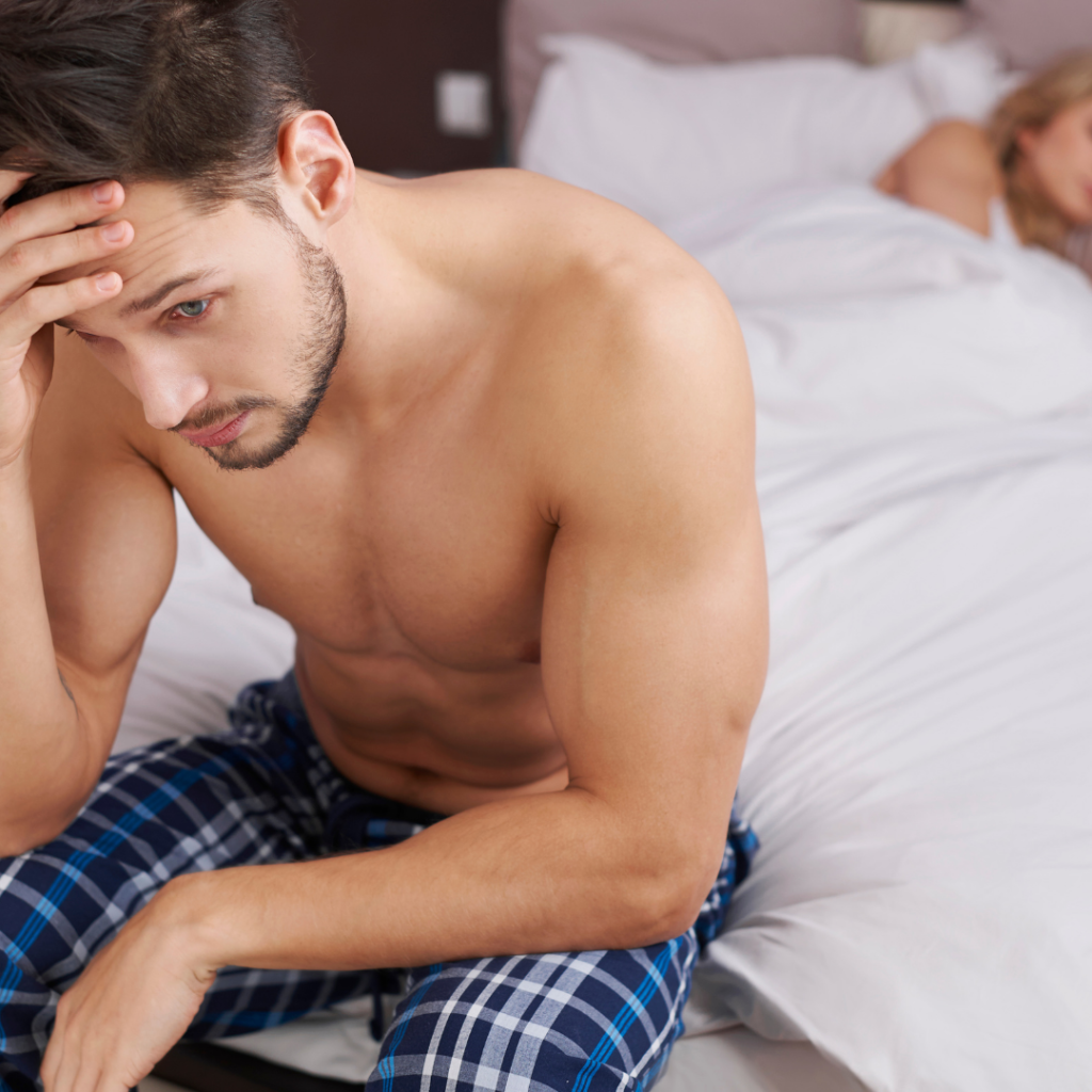 Man sitting on side of bed stressed out