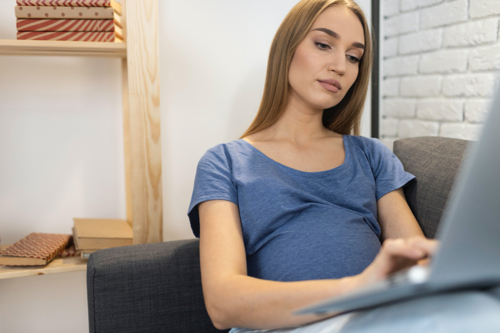 Pregnant businesswoman on the sofa with laptop