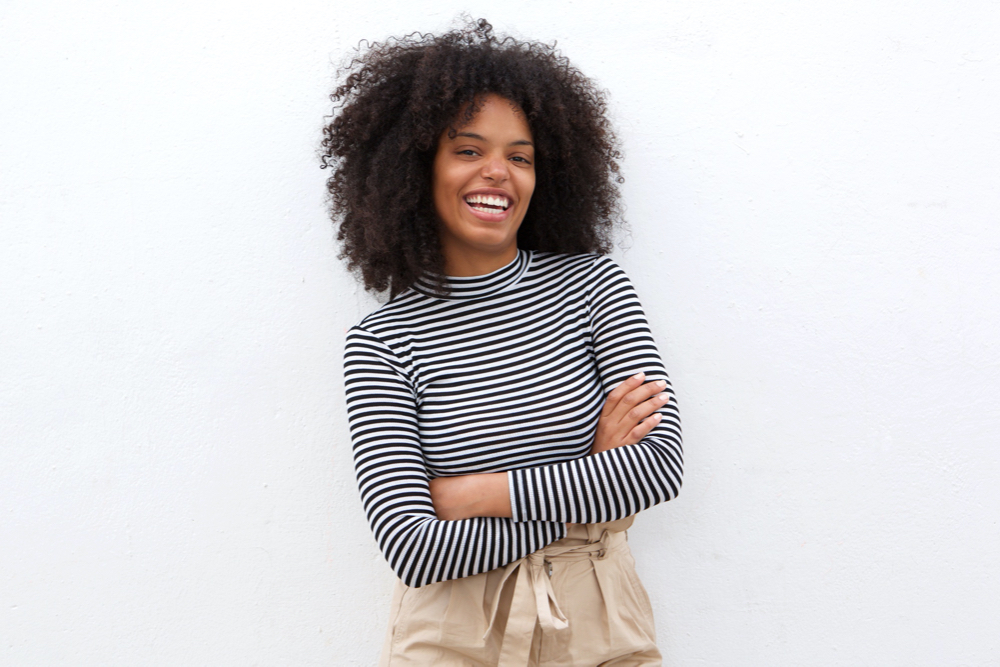Smiling black woman in striped shirt with arms crossed