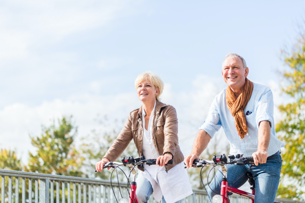 Senior couple with bicycles on bridge