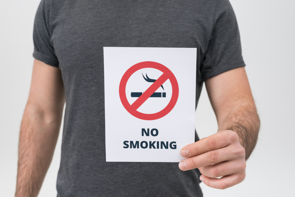 mid section of man showing no smoking sign isolated on white backdrop