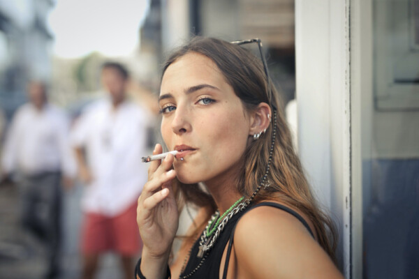 photo portrait of a young female smoking in the street