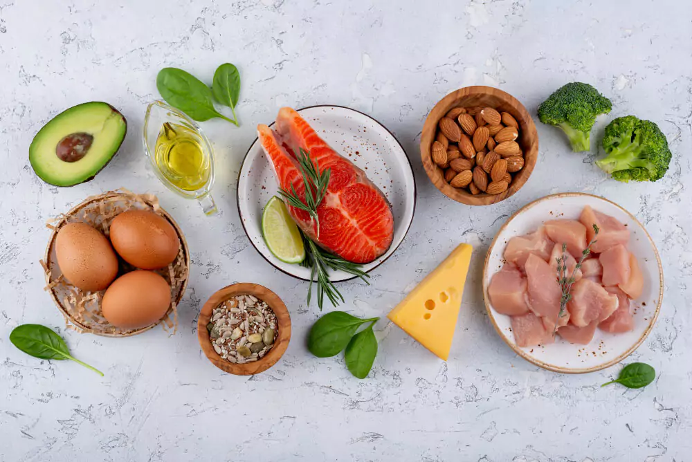 vitamin b12 rich foods on table and organized in different bowls. Salmon, poultry, broccoli, avocado, and almonds