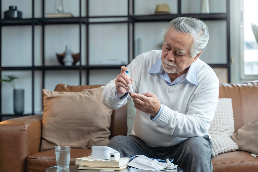photo old senior asian male hand diabetes testing tests by himself at home 