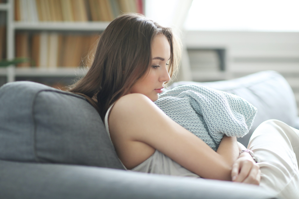 pregnant woman at home uncomfortable with a worrisome look on her face