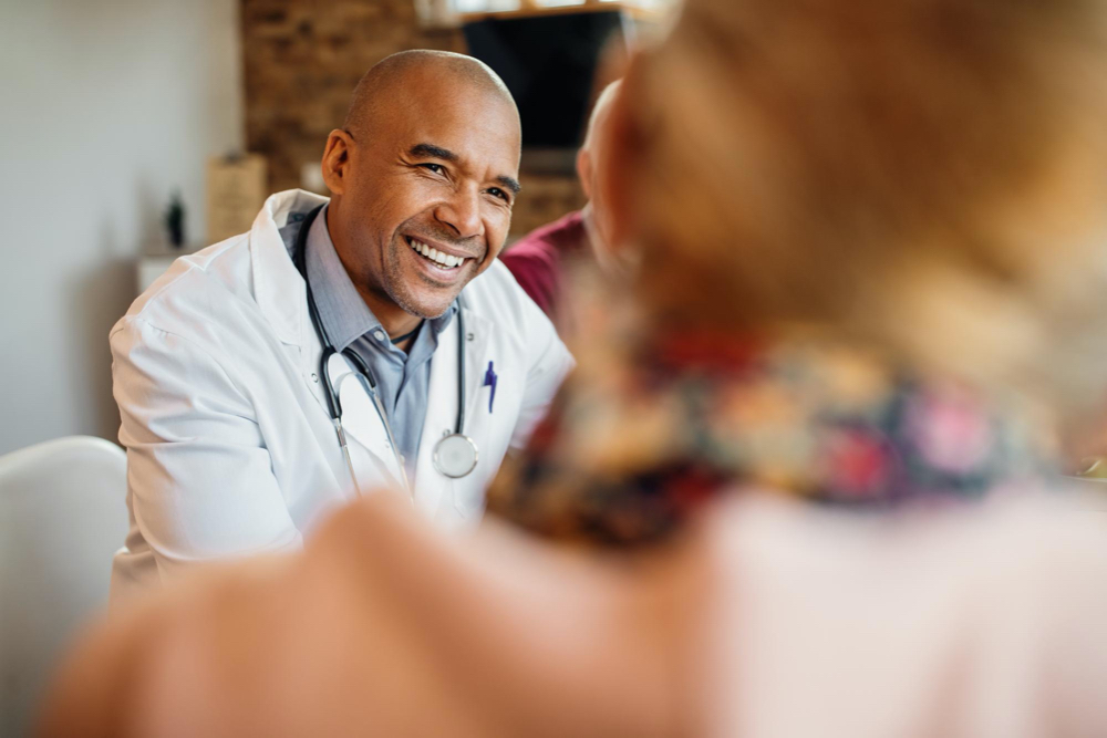 happy african american doctor in a home visit