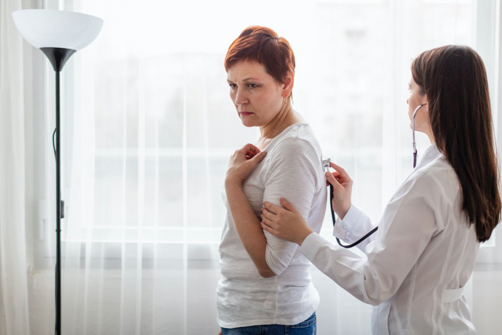 female doctor checking the breast of woman with medical problems