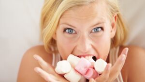 Woman eating too many marshmallows