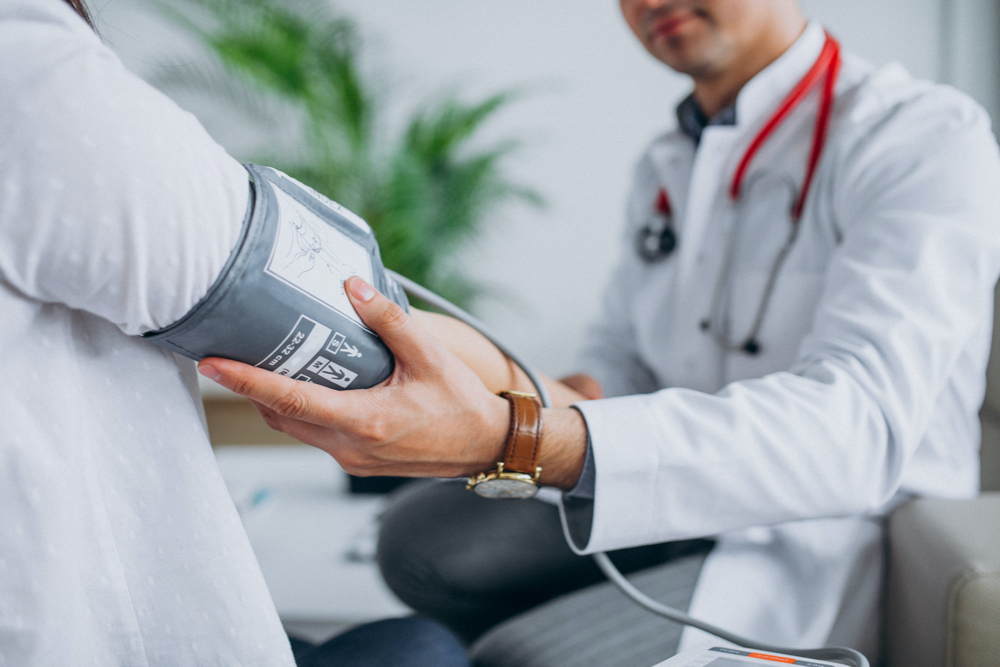 photo young male psysician with patient measuring blood pressure