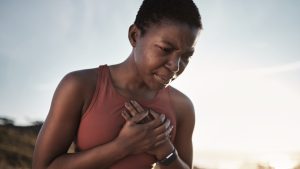 A young person experiencing heart pain while doing extreme exercise