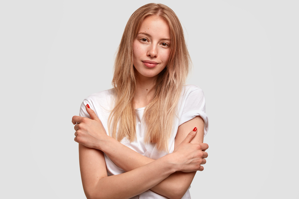 Shy beautiful blonde woman with crossed hands, dressed in casual clothes having dry itchy skin