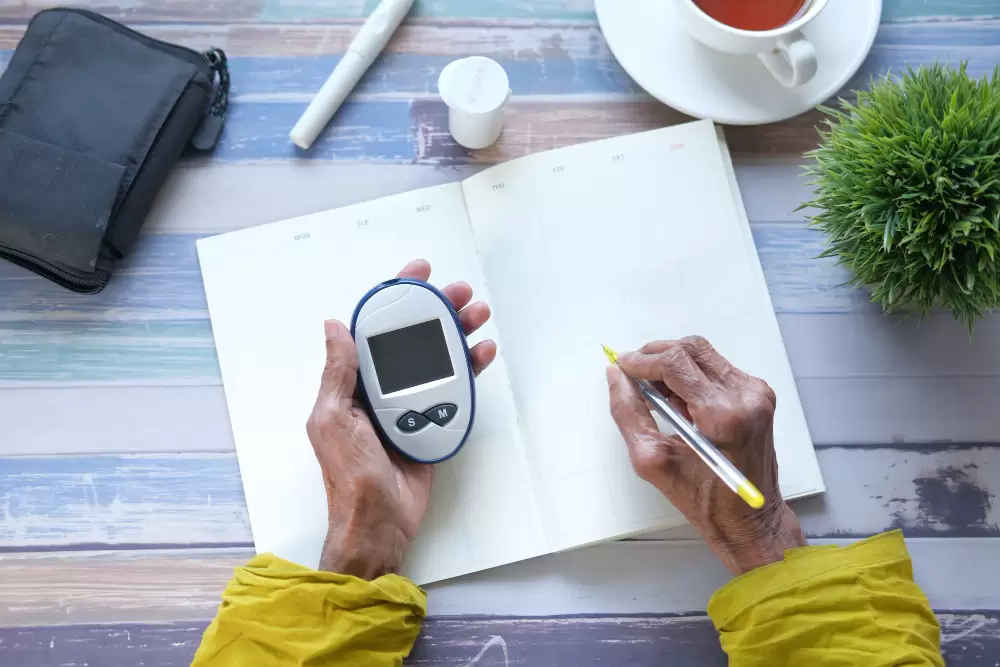 Senior women holding glucose meter and writing on a planner ,
