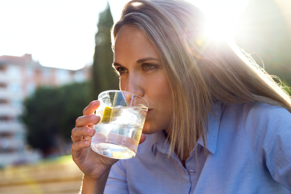 woman drinking cold water outside