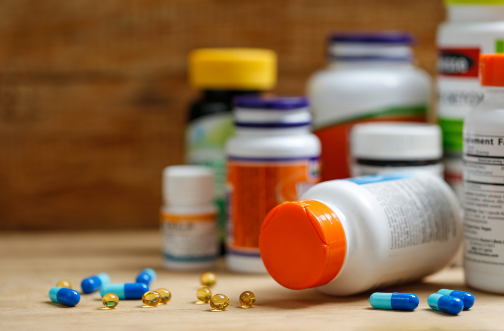 Medicine bottles and tablets on wooden desk
