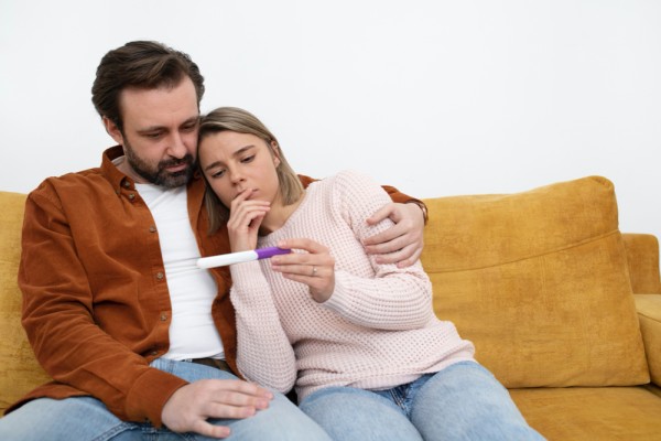 Medium shot couple with pregnancy test